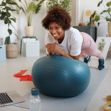woman using exercise ball to plank at home