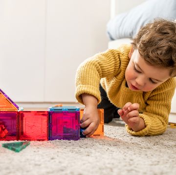 three year old boy playing with magnetic tiles