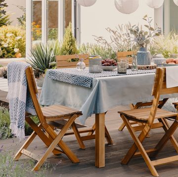 outdoor table and chairs set for a dinner party with paper lanterns