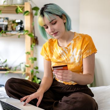 young woman with colored hair is shopping online with a credit card